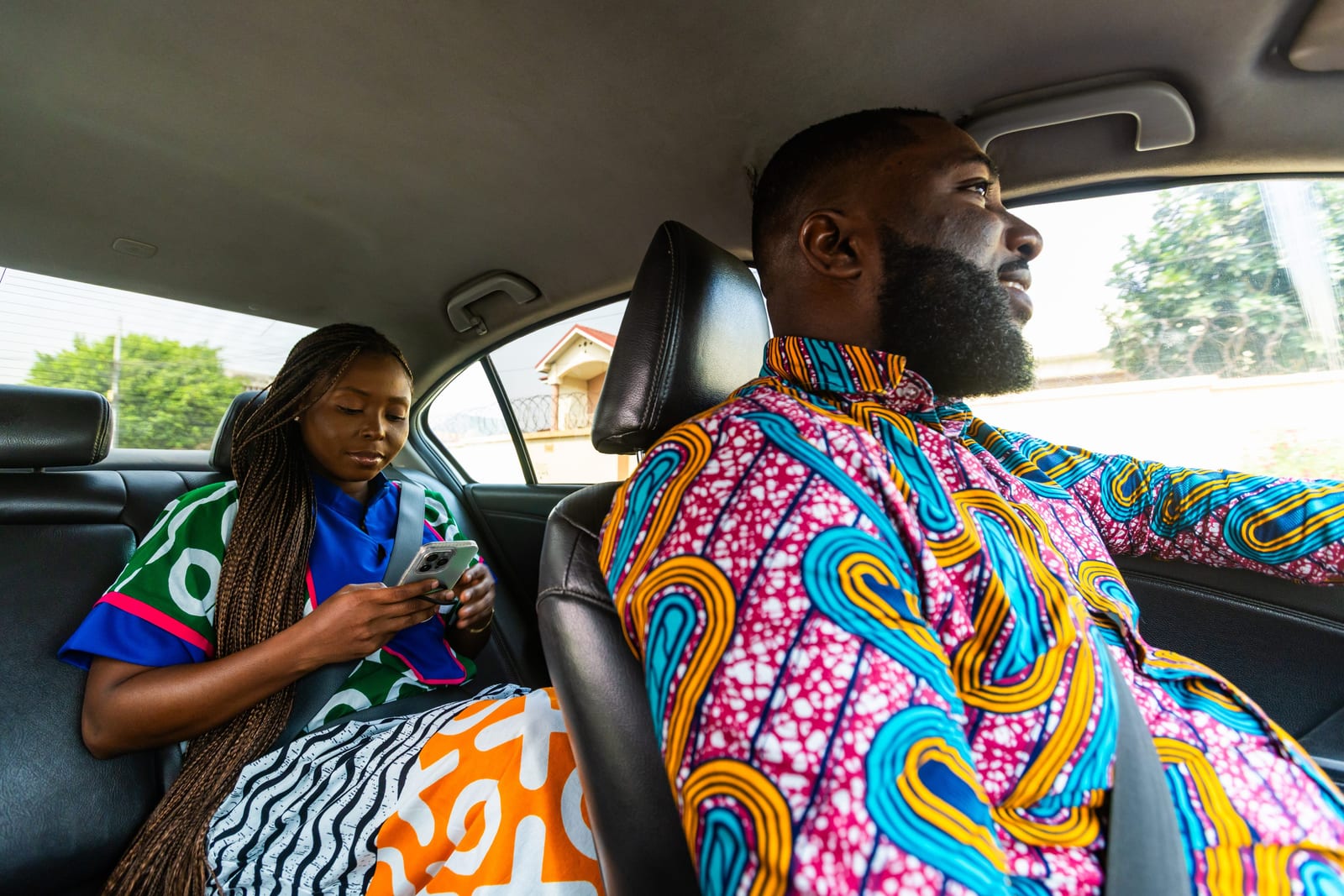Rider seated in a car using her phone while commuting